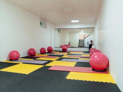 Empty modern gym space with natural lighting and mats